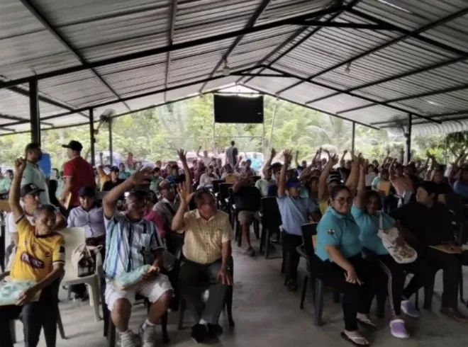Asamblea general de socios votando a mano alzada